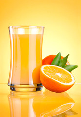 Glass of Fresh Orange juice on yellow background