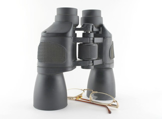 Binoculars and eyeglasses over white