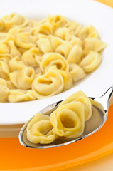Tortellini in brodo sul cucchiaio, piatto tipico italiano
