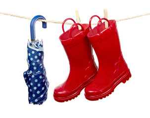 Red rain boots and a blue umbrella on a clothes line