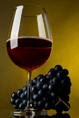 A glass of red wine and grapes