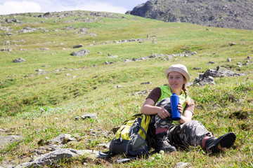 Fototapeta na wymiar mountains tourist drinking water from bottle at mountain peak