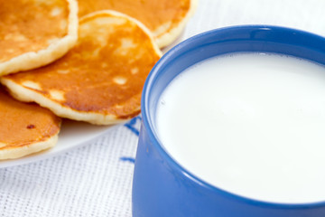 Pancakes on a plate and a cup of milk