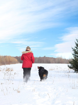 Woman Walking With Dog In Snow