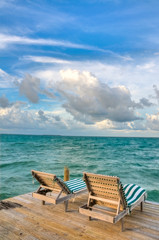 Fototapeta na wymiar Beach Chairs on a Dock Overlooking the Ocean