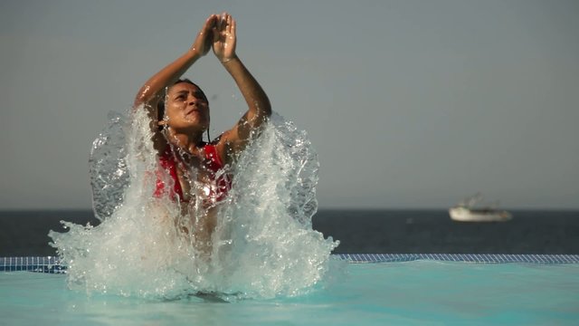Frau springt im Pool (Zeitlupe)