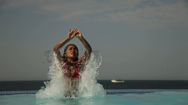Frau springt im Pool