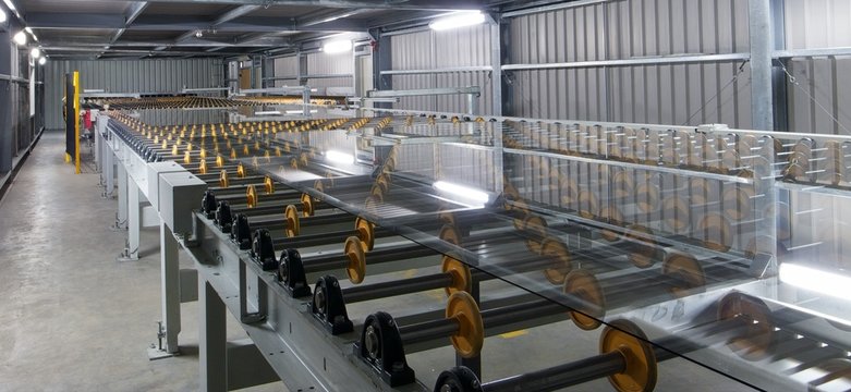 Large sheets of glass on rollers.