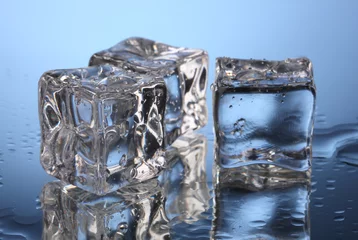 Foto op Plexiglas Smeltende ijsblokjes op blauwe achtergrond © Africa Studio