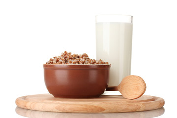 Boiled buckwheat in a brown bowl a glass of milk