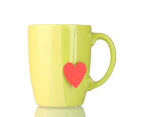 Green cup and tea bag with red heart-shaped label isolated