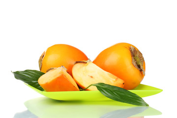 Two appetizing persimmons on green plate isolated on white