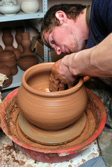 hands of a potter, creating an earthen jar on the circle