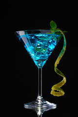 Blue cocktail in glass on black background