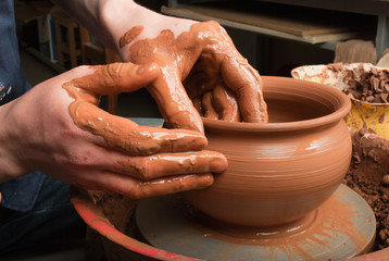 hands of a potter, creating an earthen jar on the circle