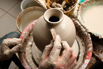 hands of a potter, creating an earthen jar on the circle