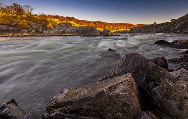 White water river and rocks in sunset light