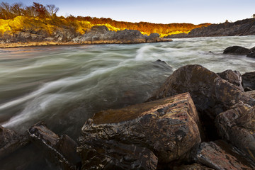 White water river and rocks in sunset light