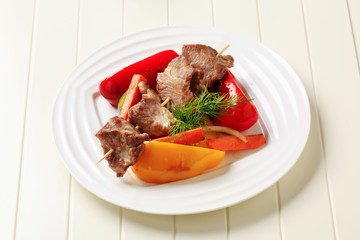 Roasted meat on skewer and baked vegetable