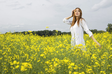 Fototapeta premium brunette woman in a yellow flowers field