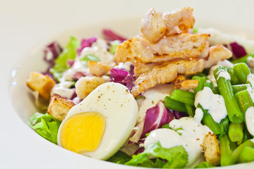 Chicken salad with green beans, cooked egg and cream in a white