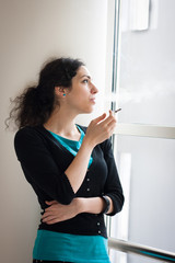 Young woman smoking indoors