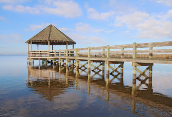 Gazebo, dock, blue sky and clouds over calm sound waters