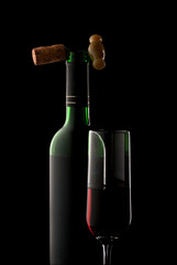 Bottle and glass of wine in black