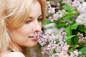 Fototapeta premium Woman with lilac flower on face