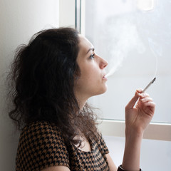 Young woman smoking indoors