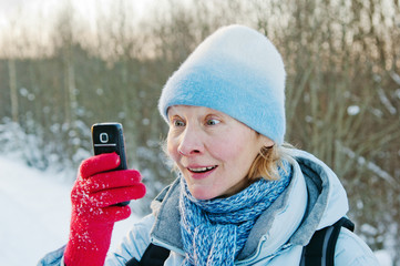 The woman photographes on a mobile phone in winter on walk