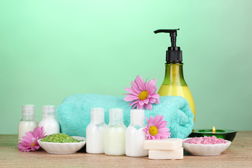 Hotel amenities kit on wooden table on blue background