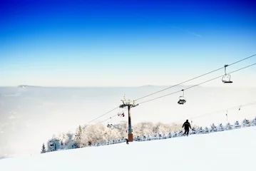 Fotobehang Winter landscape with a ski lift and ski slope © leszekglasner