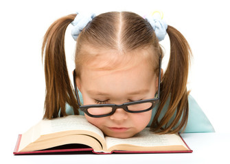 Little girl is sleeping on a book