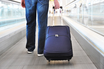 Traveler with a suitcase on the speedwalk