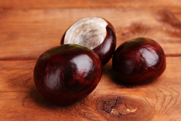 brown chestnuts on wooden background