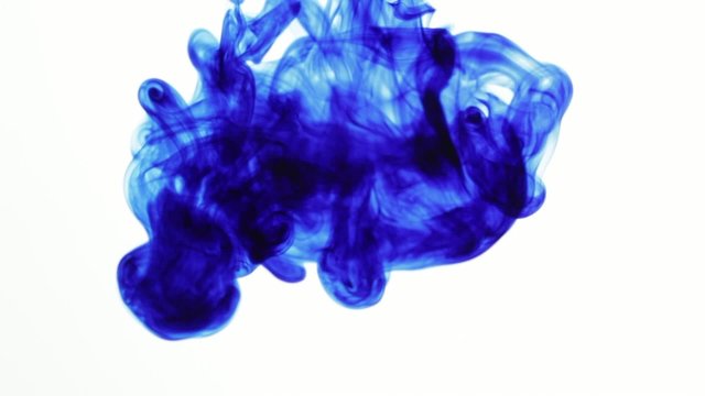 Blue ink drops in water on white background slow motion