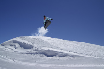 Naklejka na ściany i meble Snowboarder jumping in terrain park