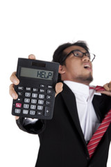 Stressed businessman holding a calculator asking for help