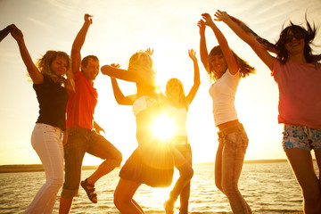happy young people dancing at the beach
