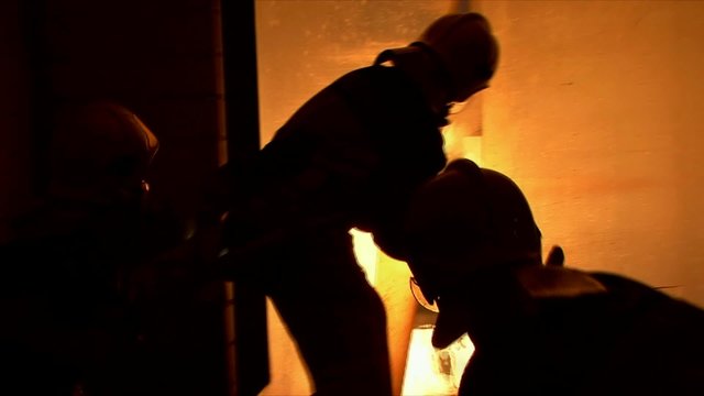 Die Feuerwehr in einem brennenden Haus im Einsatz