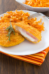 Chicken cordon bleu with grated carrots.