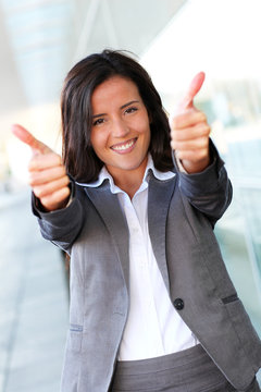 Cheerful businesswoman showing tumbs up