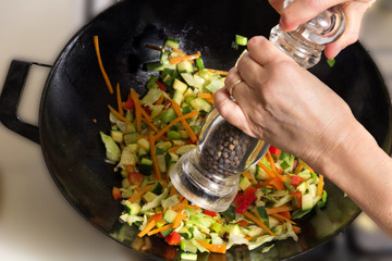 Peppering food in wok