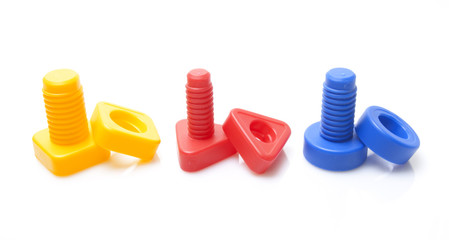 Colourful toy nuts and bolts on white background