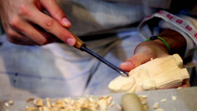 Carver cuts a wooden toy and compares it with other