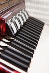 Red accordion and sheet music, close up