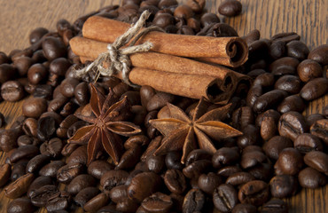 coffee grains and spices on wooden background