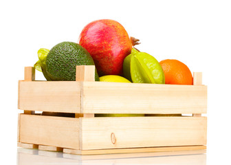 Assortment of exotic fruits in wooden box isolated on white