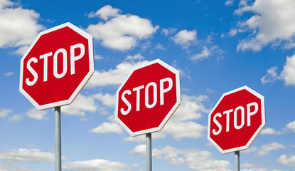 Stop signs - against the sky - obrazy, fototapety, plakaty